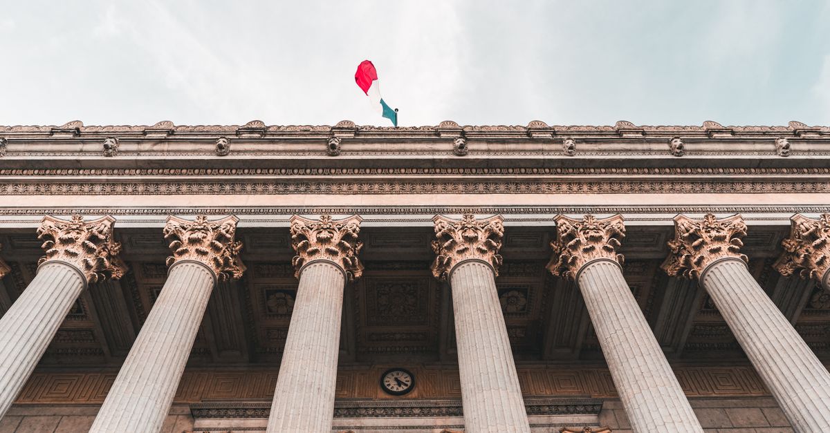 Majestic columns of Palais de Justice in Lyon with French flag on top, a classic architectural masterpiece.