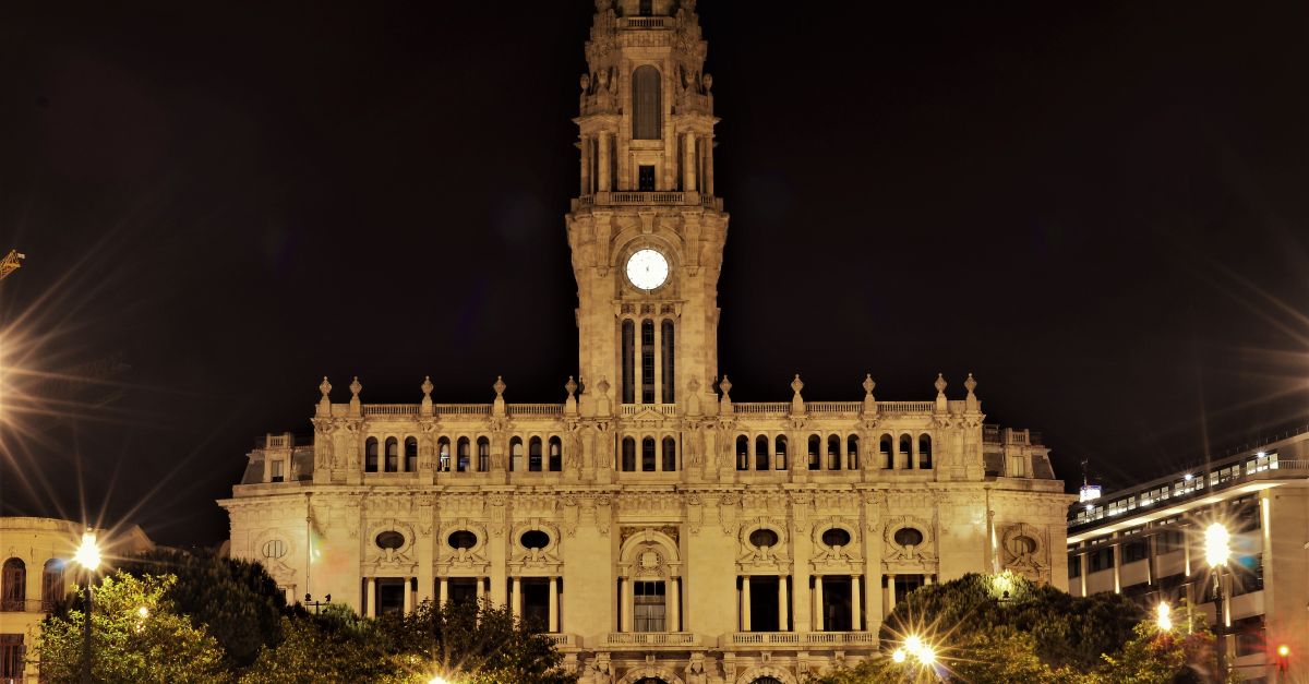Dramatic night view of the illuminated Porto City Hall, an architectural landmark in Portugal.