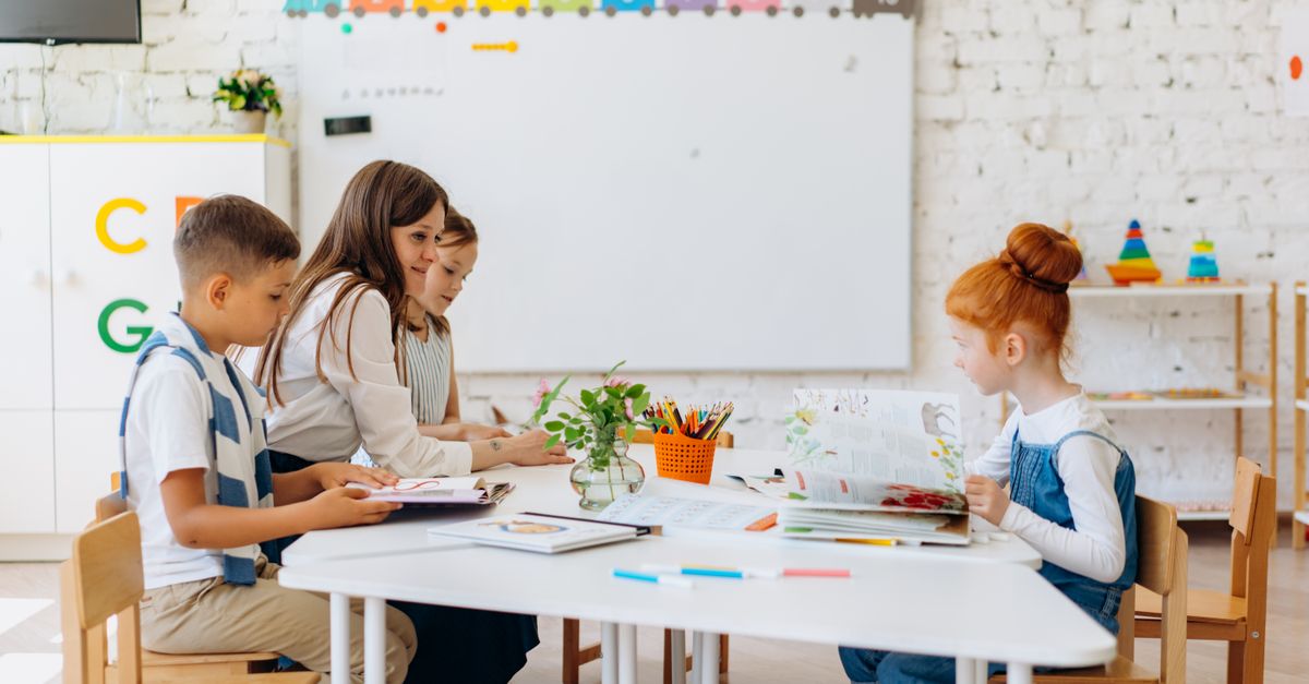 Students and teacher interacting in a bright, colorful classroom setting.