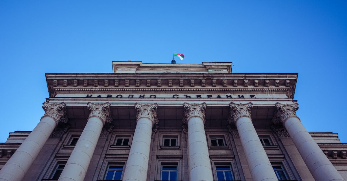 Low-angle view of Sofia's Parliament Building with majestic columns and clear sky.