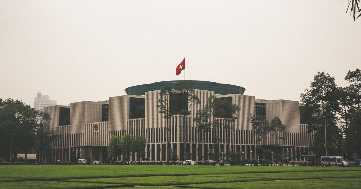 View of the Vietnam National Assembly Building in Hanoi with Vietnamese flag.