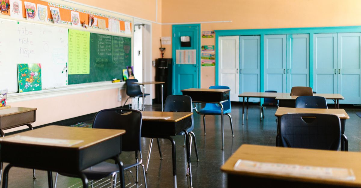 Bright and colorful empty classroom with desks, blackboard, and educational materials.