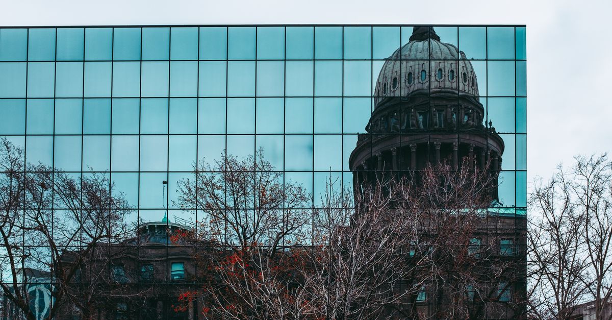 Reflection of Idaho State Capitol in a mirrored building facade in Boise, ID.
