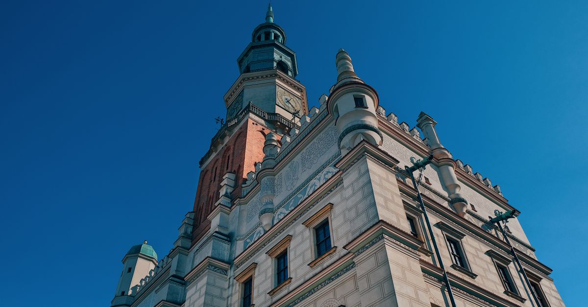 Low-angle shot of the historic town hall tower in Poznań against a clear blue sky.