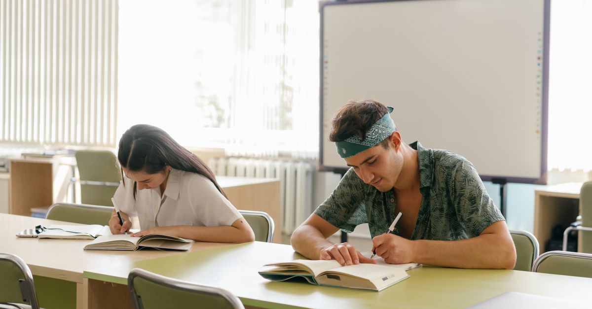 Two students focused on study in a bright, modern classroom.