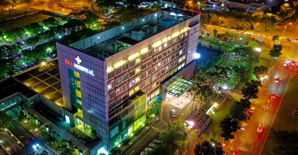 Stunning aerial view of Eka Hospital in Serpong, Indonesia, illuminated at night, capturing vibrant city lights and architecture.