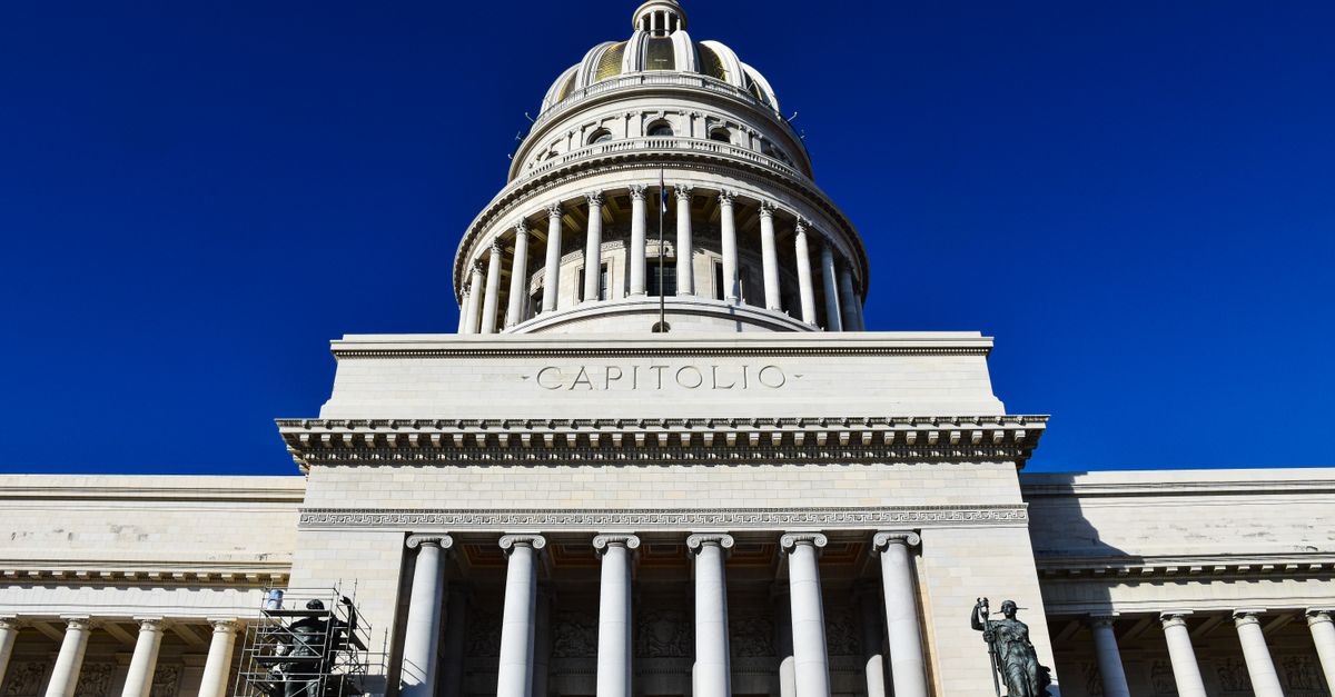 Low angle view of the iconic El Capitolio building under a clear blue sky in Havana, Cuba.