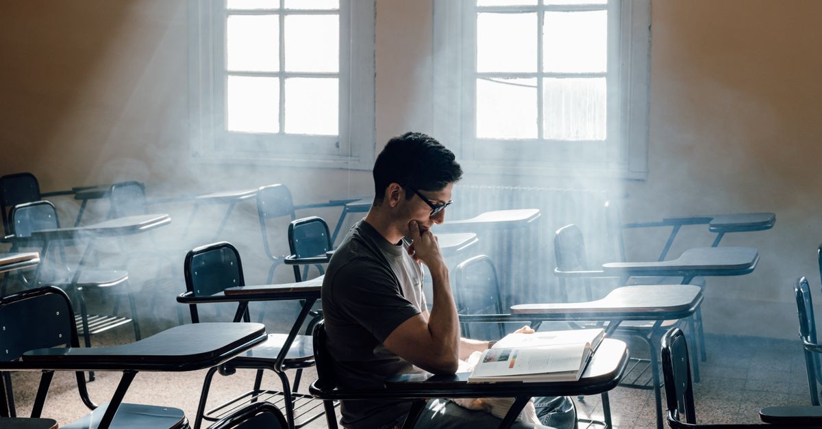University student studies alone in a sunlit classroom, Buenos Aires, Argentina.