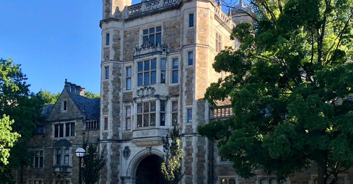 Stunning Gothic Revival architecture of a university building with lush greenery.